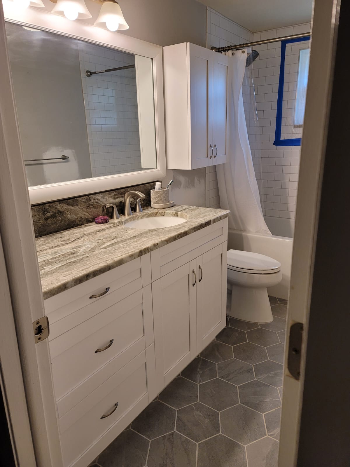 Modern bathroom with white cabinetry and marble countertop