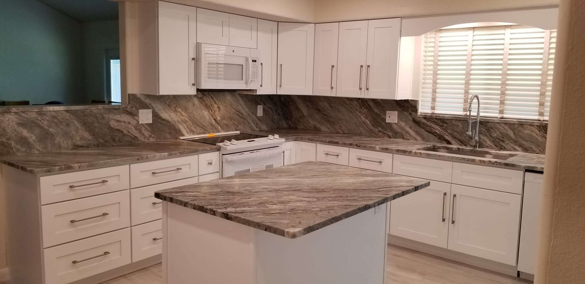 Modern kitchen with marble countertops and white cabinetry