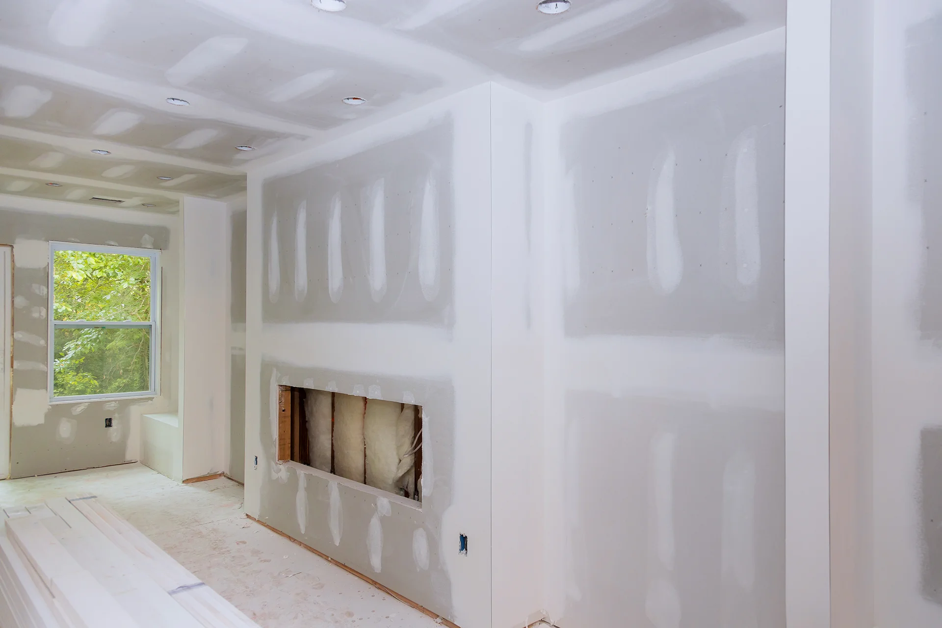Drywall installation in a new home, framed around a fireplace