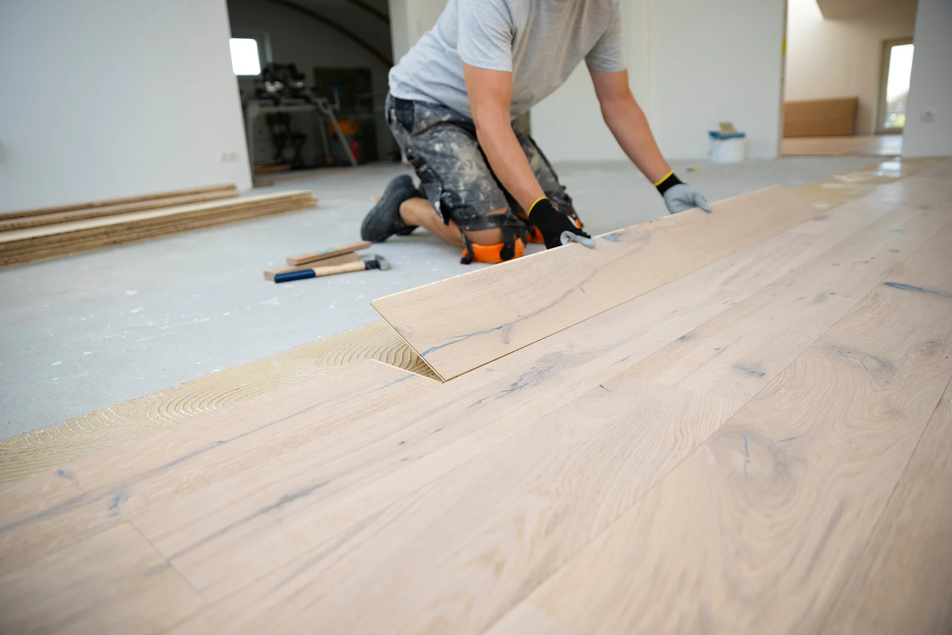 Engineered oak plank flooring being installed by hand
