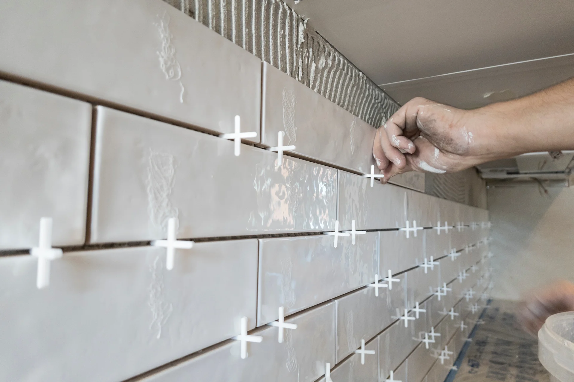 White subway tile backsplash being installed during a kitchen remodel